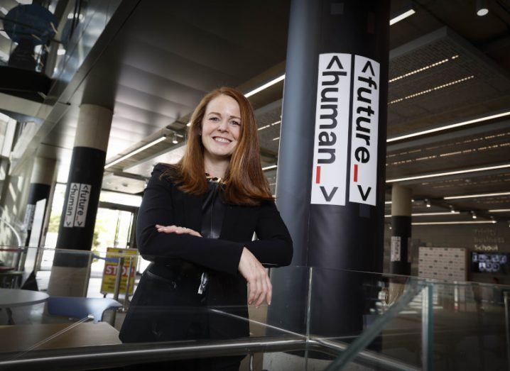 Jillian Slyfield of Aon stands beside a pillar with the Future Human logo on it.