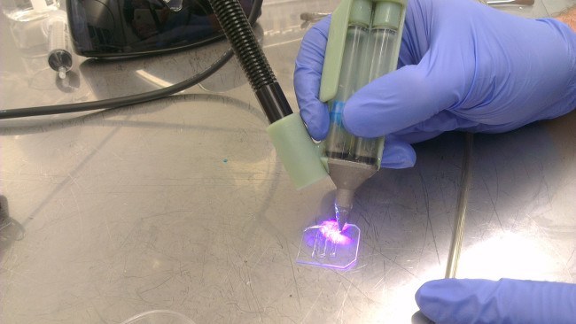 Photo showing biopen printing in action, the UV light causes the liquid bioink to gel, forming a matrix which resembles native cartilage