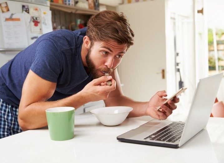 Man getting his breakfast and news at once