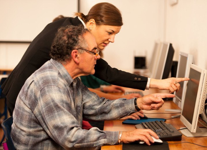 Women: woman teaching man how to use computer