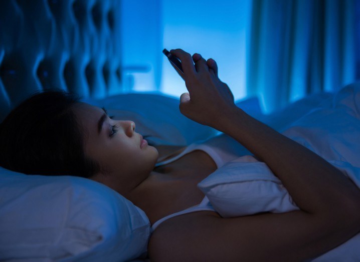 Digital-human interaction: woman using phone in bed
