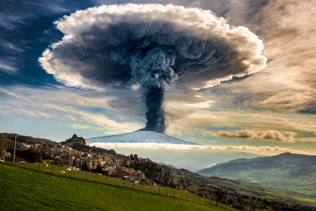 An Etna eruption seen from San Teodoro. The quiet of the grazing flocks and the tranquility of the village are in contrast to the enormous explosive force of the volcano – image via Fernando Famiani, single image finalist at Magnum and LensCulture Photography Awards 2016