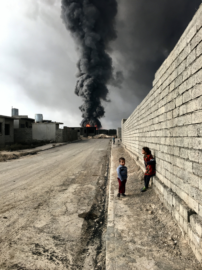 Sebastiano Tomada, USA. Grand Prize winner – photographer of the year category, IPPA. Children of Qayyarah: “Children roam the streets in Qayyarah, Iraq, near the fire and smoke billowing from oil wells set ablaze by Islamic State militants.”