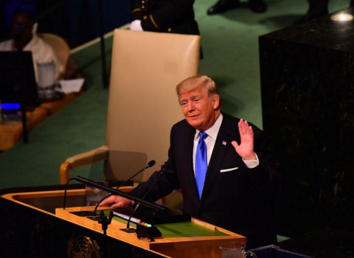 Donald Trump speaking at a podium.