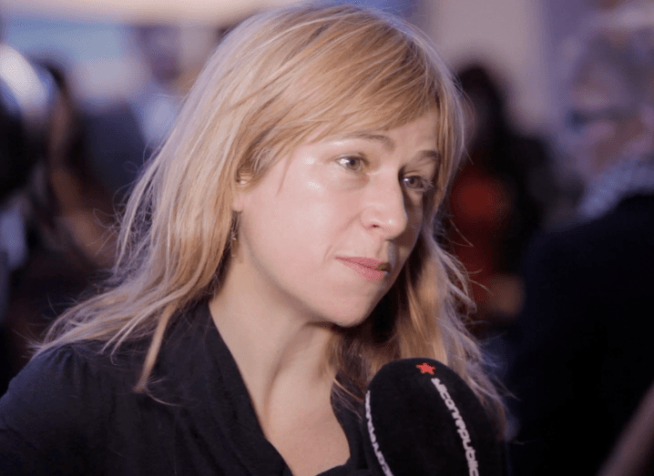 close-up of blonde woman speaking into microphone with Silicon Republic branding.