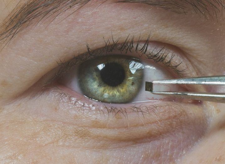 Person holding tiny sensor in front of their eye