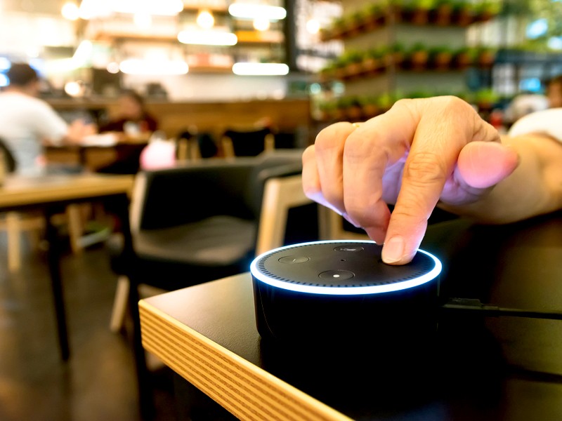 Picture of a hand touching Amazon Echo dot