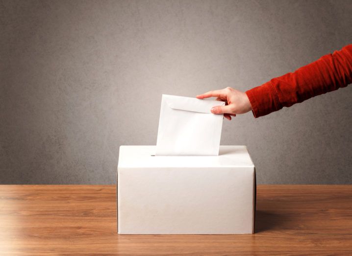 ballot box with someone casting their vote