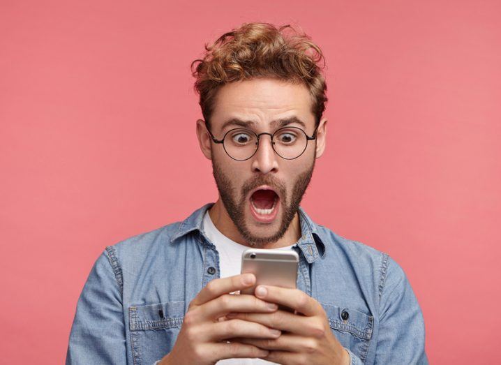 Horrified hipster with smartphone