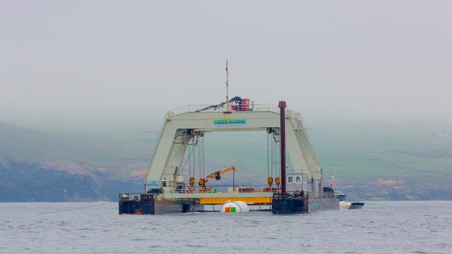 Project Natick’s Northern Isles data centre is partially submerged and cradled by winches and cranes between the pontoons of an industrial catamaran-like gantry barge
