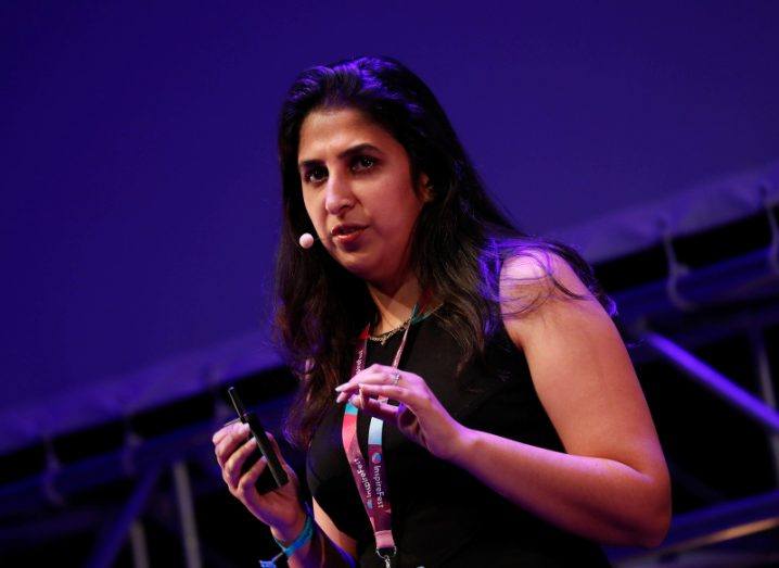 Surbhi Sarna presents her talk in the purple lighting of the Inspirefest stage, wearing a head mic and Inspirefest lanyard