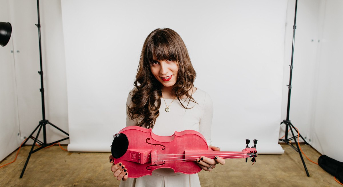Kaitlyn Hova holding a pink violin.
