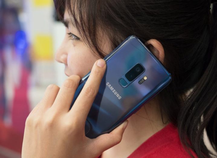 woman holding Samsung S9 smartphone to her ear