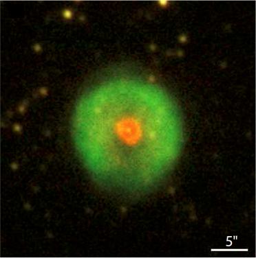 A image of a green planetary nebula with an orange central star against a starry background.