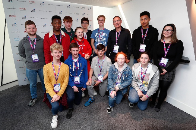 Two rows of teenagers, some kneeling and some standing, smile for a photo with Silicon Republic.