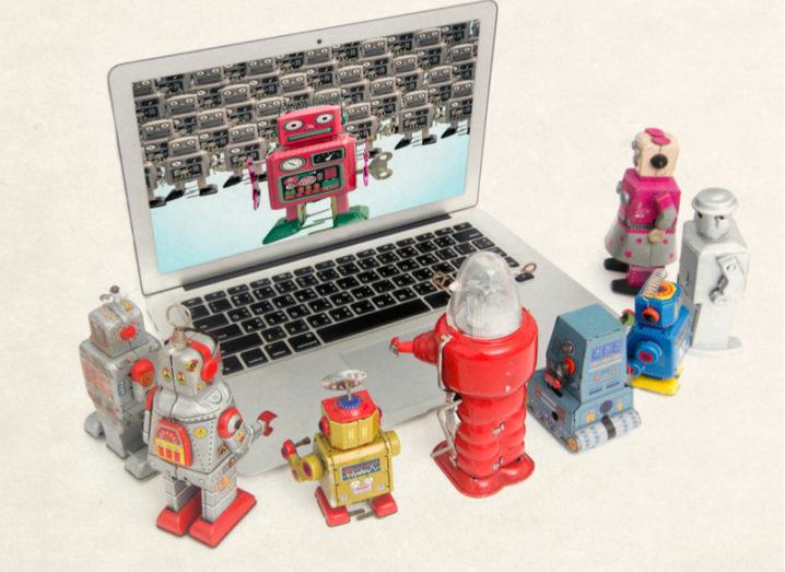 A picture of robots clustered around a computer learning from another robot.
