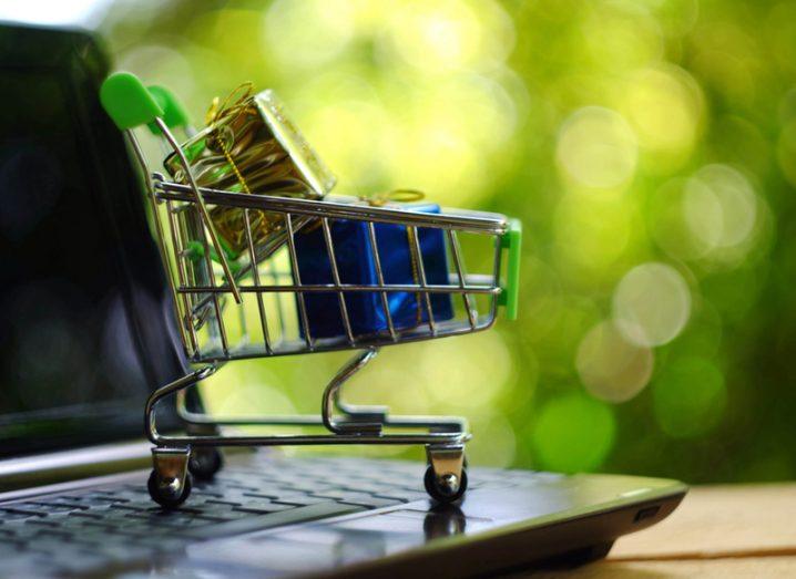 Picture of a shopping trolley filled with goods standing on a computer keyboard.