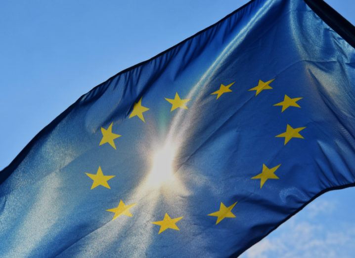 Close-up of an EU flag flying in the sun with lens flare.