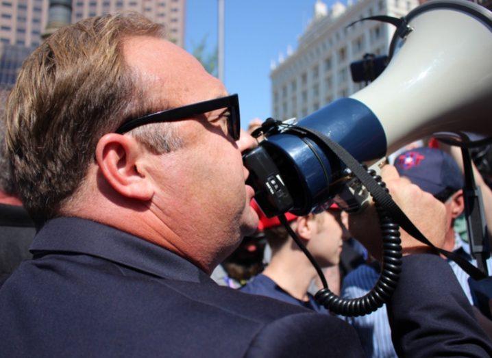 Alex Jones using a megaphone at a protest.