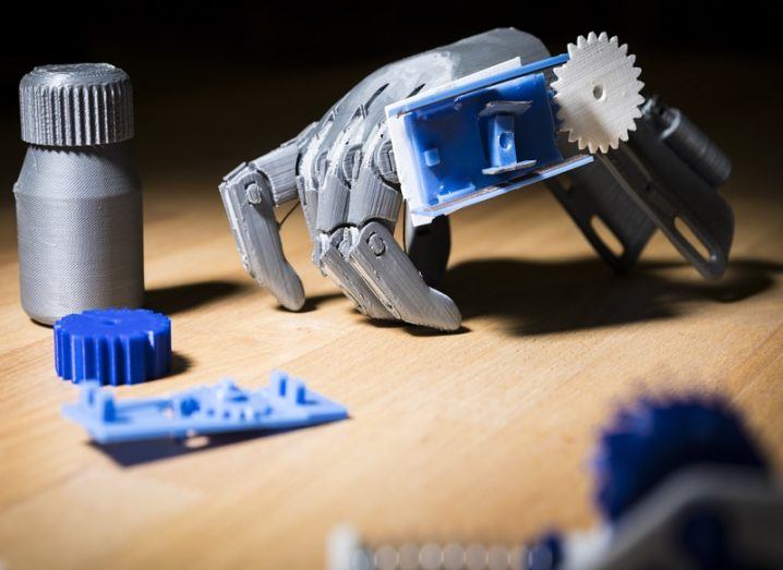 Close-up of 3D-printed sensors and a prosthetic hand on a table.