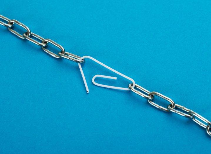 A paperclip clumsily connects two points on a string of chain links against a sky blue background.