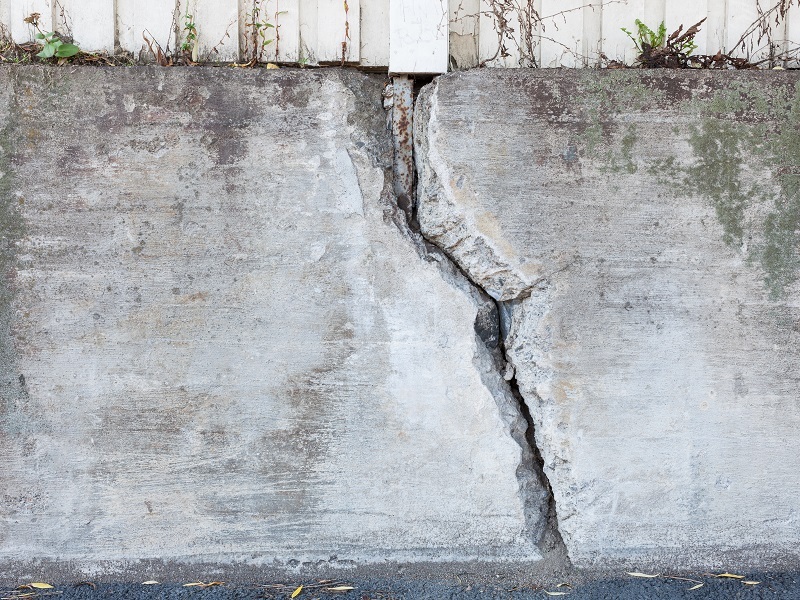 Big crack in an old, outdoor concrete wall.