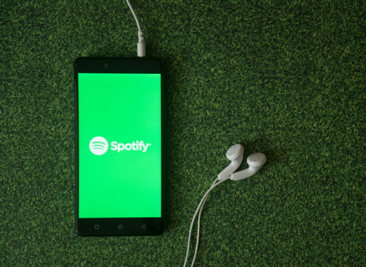 Spotify on a mobile device with headphones.