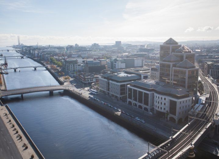 Aerial view of Dublin's Liffey with a train track running across bridge.