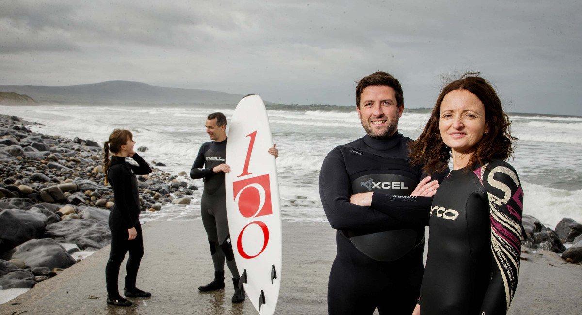 Two women and two men in surf gear on a Sligo beach.