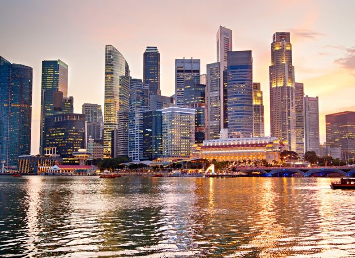 The skyline of Singapore at sunset, featuring many impressive skyscrapers.