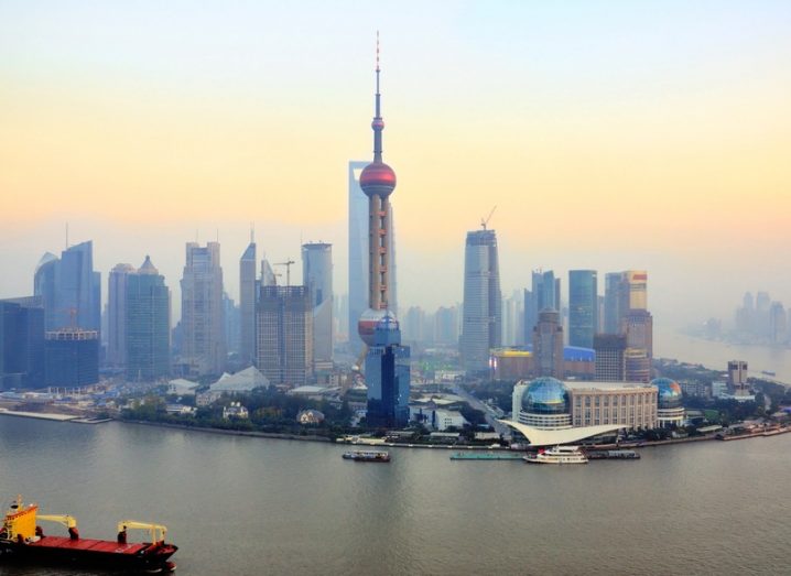 The skyline in Shanghai, with a misty yellow sunset in the background.