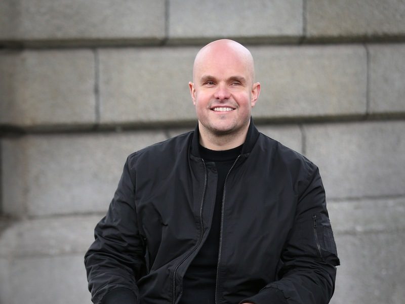 Mark Pollock photographed sitting outside Trinity College Dublin, sitting in his wheelchair,