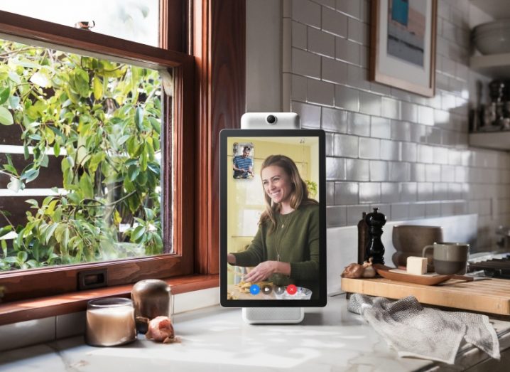 Facebook portal device on a kitchen counter, displaying a woman on a video call.