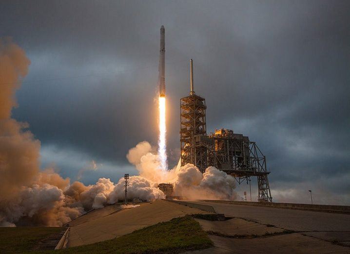 A SpaceX Falcon 9 rocket taking off from a launch pad.