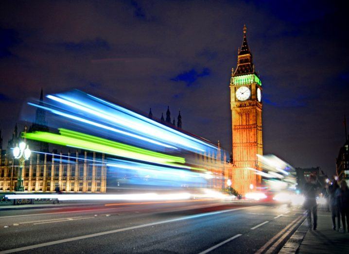 Timelapse shot of a bus driving across London Bridge in front of Big Ben and the UK parliament.