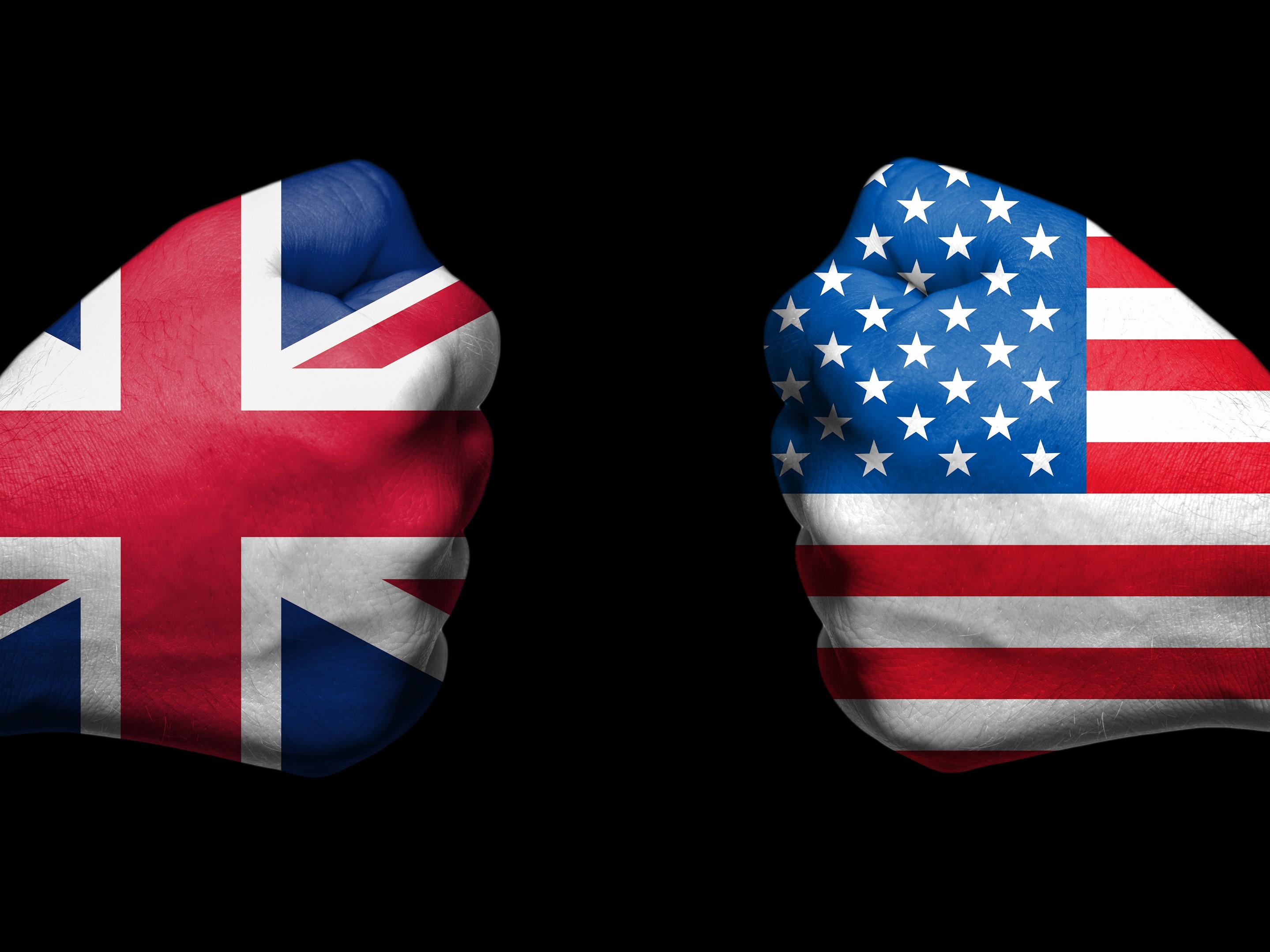 two fists emblazoned with the flags of the UK and US face each other.