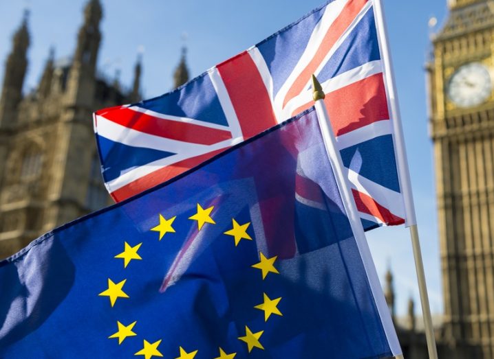 A Union Jack flag and an EU flag outside the UK houses of parliament.