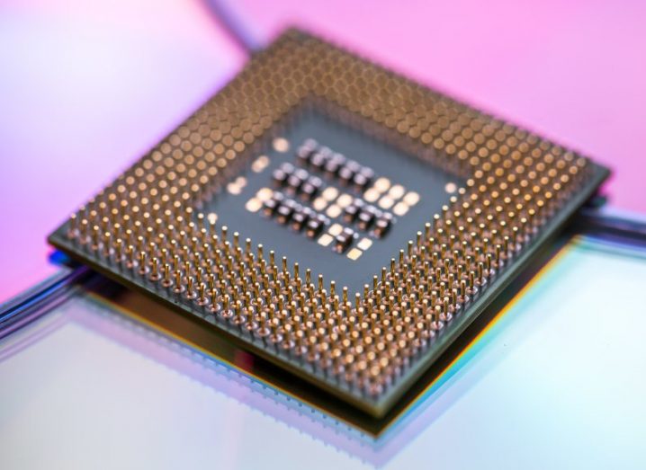 A microchip lying on a blue and pink background.