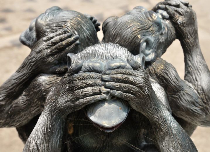 Sculpture of three apes in a circle, one covering its ears, one covering its mouth and the one in front covering its eyes.