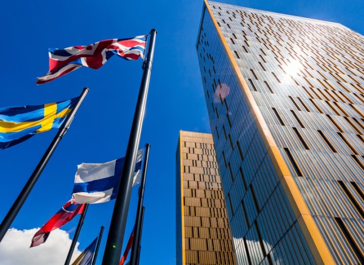 A high-angle photo of the European Court of Justice with flags waving against a blue sky.