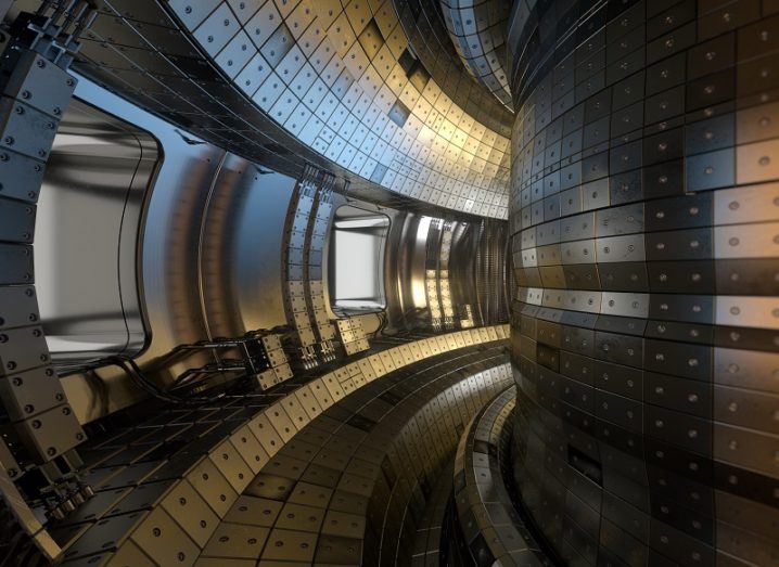 Shot from inside a silver steel, doughnut shaped tokamak nuclear fusion experimental reactor.