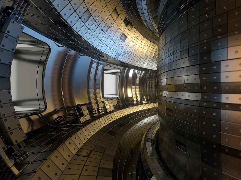 Shot from inside a silver steel, doughnut shaped tokamak nuclear fusion experimental reactor.