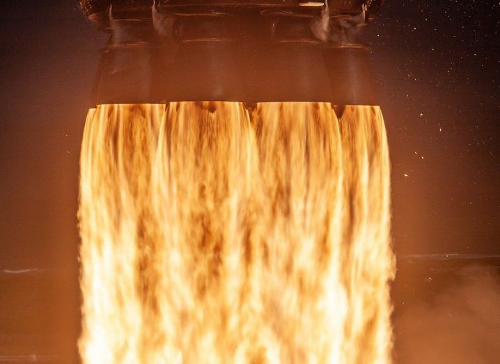 Close-up of fiery orange flames being emitted by a SpaceX rocket booster.