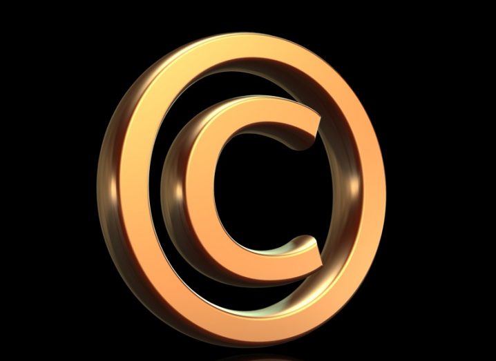 Copyright symbol (the letter C inside a circle) in gold isolated on black background.