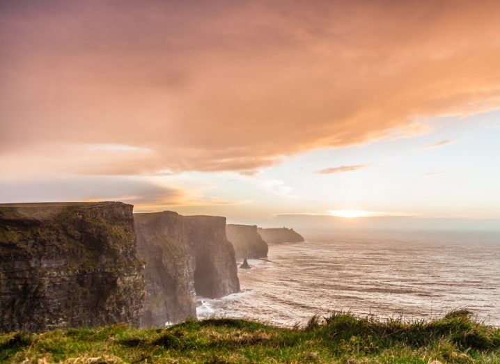 Cliffs of Moher at sunset in Co Clare, with pink clouds in the sky.