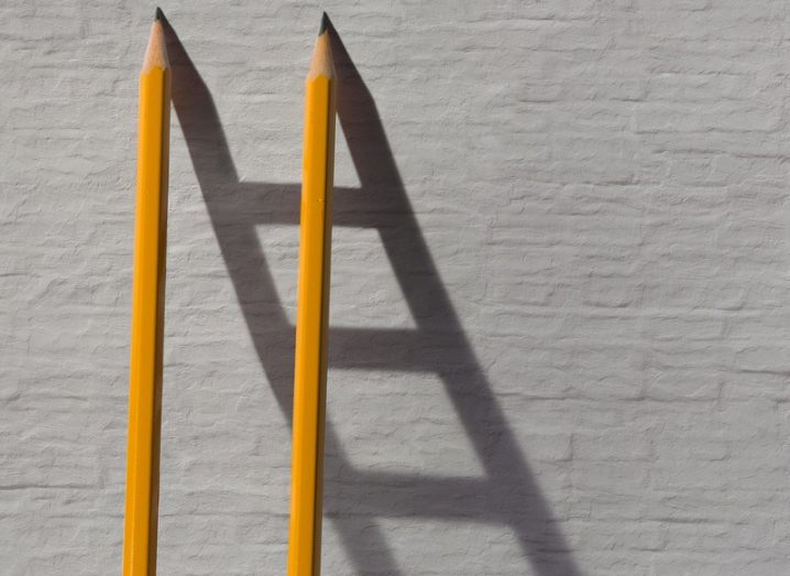 Two pencils and a shadow in form of ladder near the stone wall. Collaboration concept.