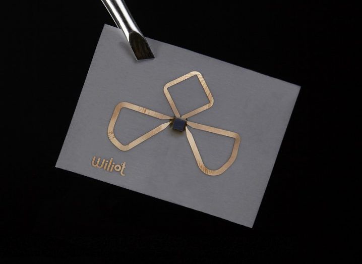 The Wiliot chip with a shamrock-like shape on its front against a black background.