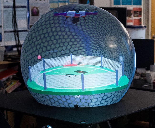 The crystal ball shaped display in the lab with a soccer pitch projection inside.