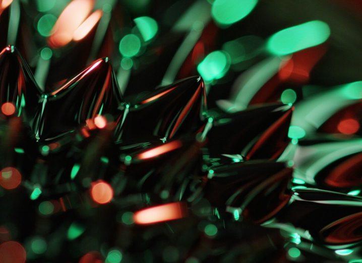 Close-up of a silver liquid on neodymium magnet creating a jagged effect bathed in green light.
