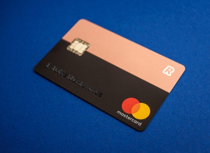 Close up view of a Revolut card issued by Mastercard against an electric blue background